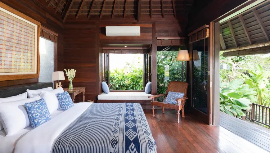 Cozy wooden bedroom with a window seat and lush garden view at Villa Bangkuang