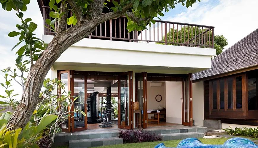 Modern communal wellness area with exercise equipment and a massage table in a bright tropical villa at Villa Bangkuang