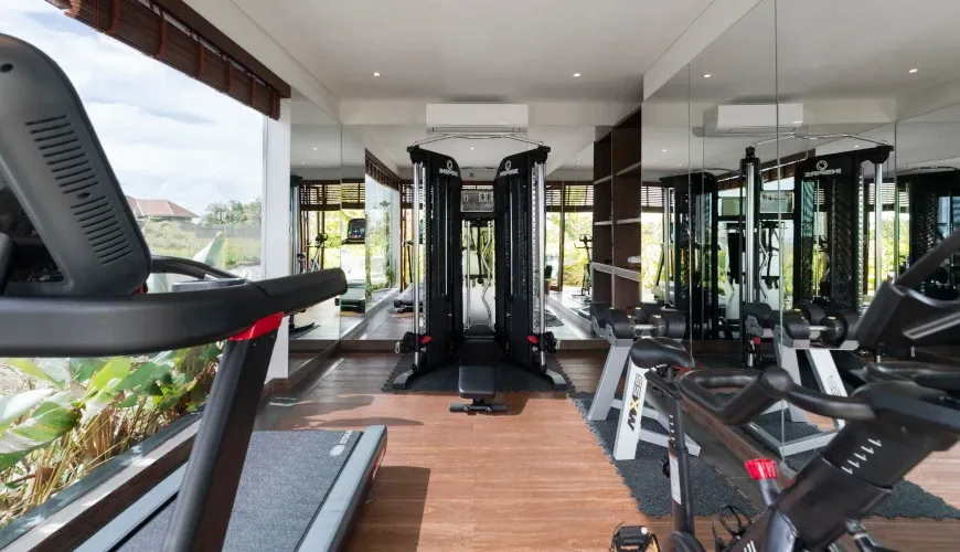 Modern gym with various workout machines and mirrors at Villa Bangkuang