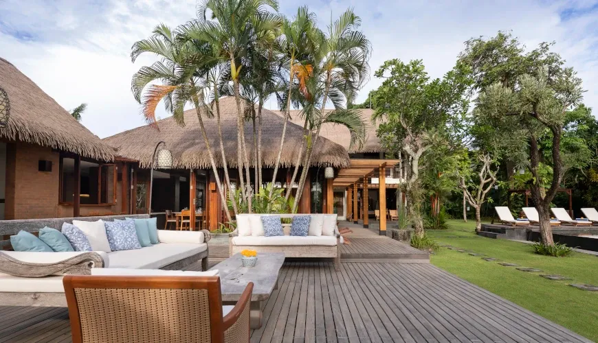 Spacious outdoor deck with seating and a lush lawn at Villa Bangkuang