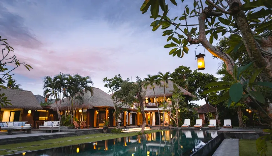 Sunset at a luxurious Bali villa with a lit pool at Villa Bangkuang