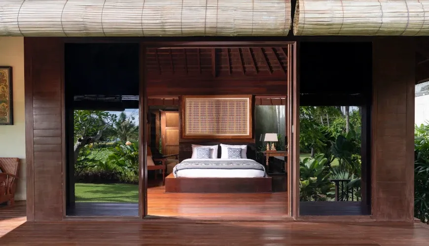 Traditional wooden bedroom with an open-air design and garden views at Villa Bangkuang