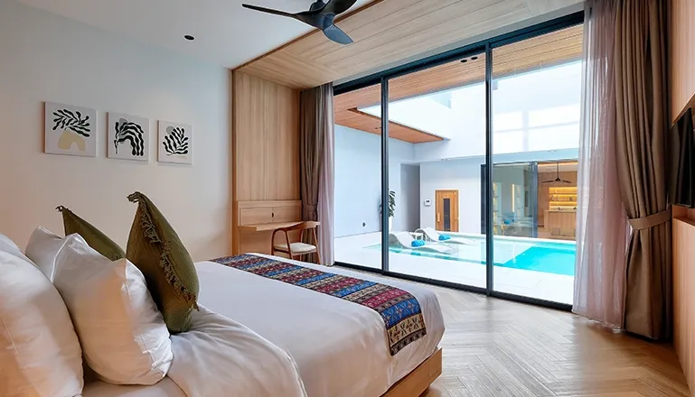 A stylish bedroom featuring a large bed and direct pool access at Villa Brandon