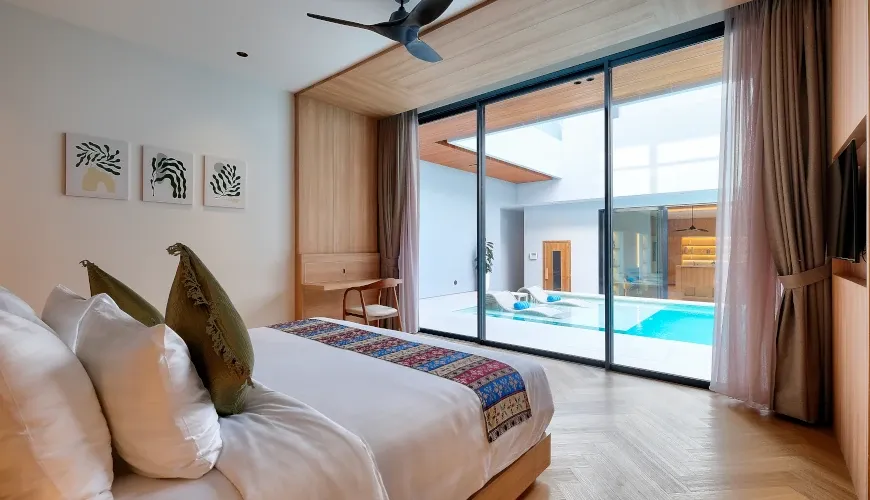 Bedroom with minimalist decor, pool view, and modern art at Villa Brandon