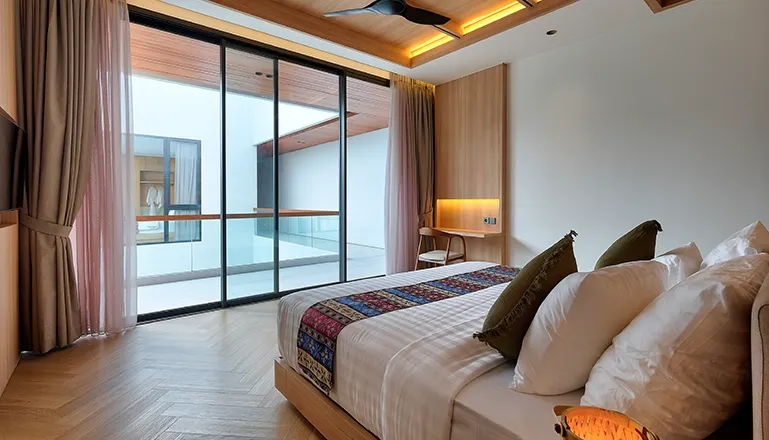 Contemporary bedroom with a large bed and expansive glass doors at Villa Brandon