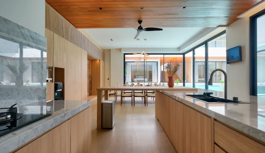 Elegant, minimalist kitchen with marble counters and wood accents at Villa Brandon