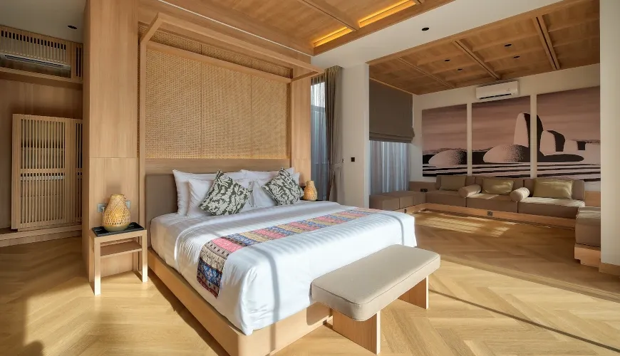 Luxury master bedroom with light wood accents and modern art at Villa Brandon