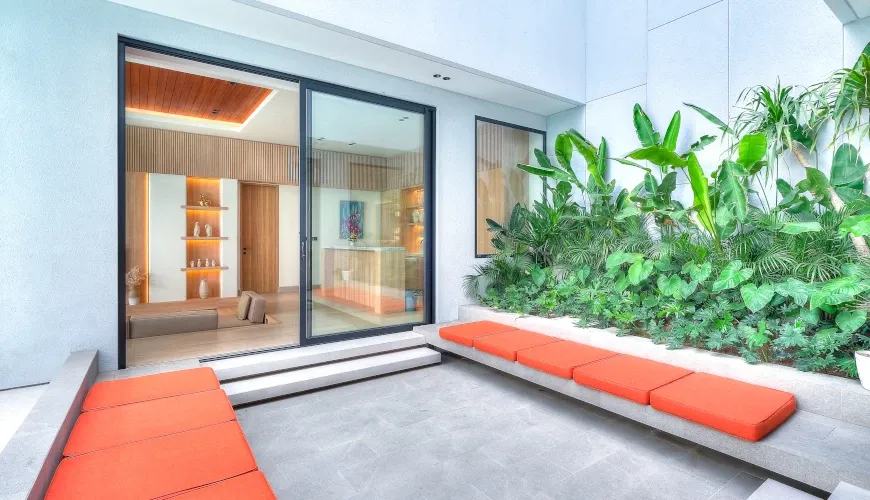 Modern courtyard with vibrant seating and lush plants at Villa Brandon