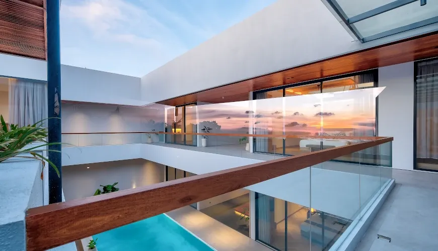 Modern villa balcony overlooking pool at sunset at Villa Brandon