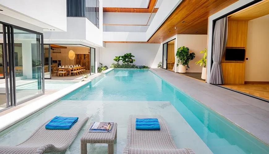 Sunny outdoor pool terrace with comfortable seating and a seamless transition to the indoor living area at Villa Brandon