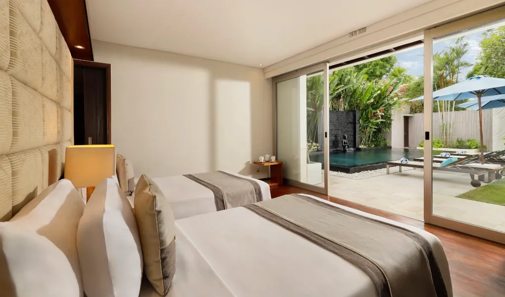Bedroom with twin beds opening to a pool area at Villa Camellia