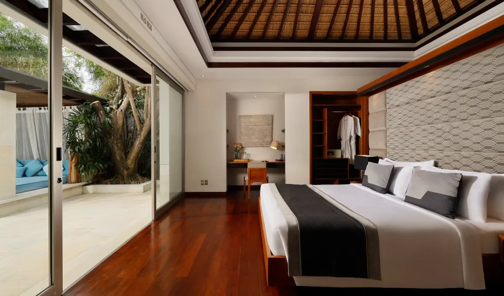 Modern bedroom with a walk-in closet and private patio at Villa Camellia