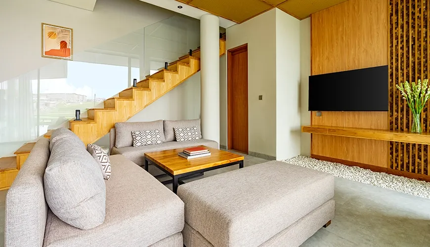 Comfortable villa seating area featuring a contemporary coffee table, mounted television, and slatted wood wall at Villa Chanthira Luxe