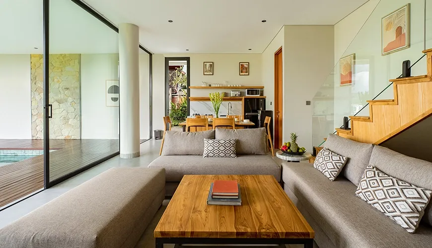 Contemporary open living room featuring large comfortable sofas, a wood coffee table, and modern art at Villa Chanthira Luxe