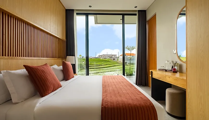 Cozy king size bedroom with large window and beautiful view of stepped green rice paddies at Villa Chanthira Luxe