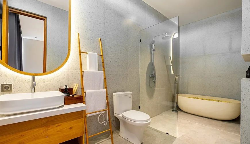 Luxurious modern bathroom featuring a floating wooden vanity and standalone soaking bathtub at Villa Chanthira Luxe