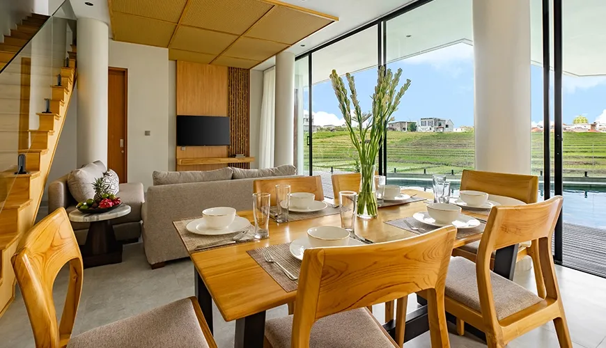 Modern luxury villa dining room featuring a wooden table set for six with great natural light at Villa Chanthira Luxe