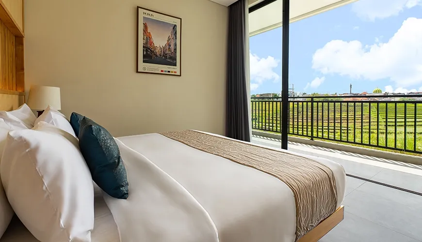 Modern queen bedroom featuring textured pillows and great natural light with views of the paddy fields at Villa Chanthira Luxe