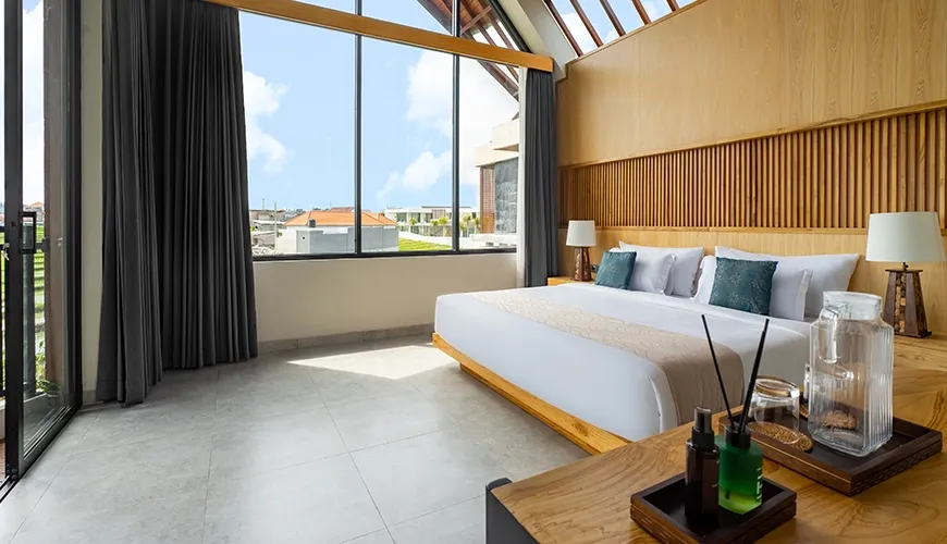 Spacious master bedroom with vaulted wood ceiling and full-length window for an incredible view at Villa Chanthira Luxe