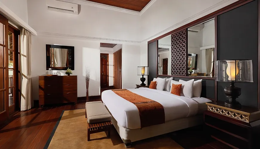 Spacious and luxurious villa bedroom with a plush bed and dark wood accents at Villa Danis