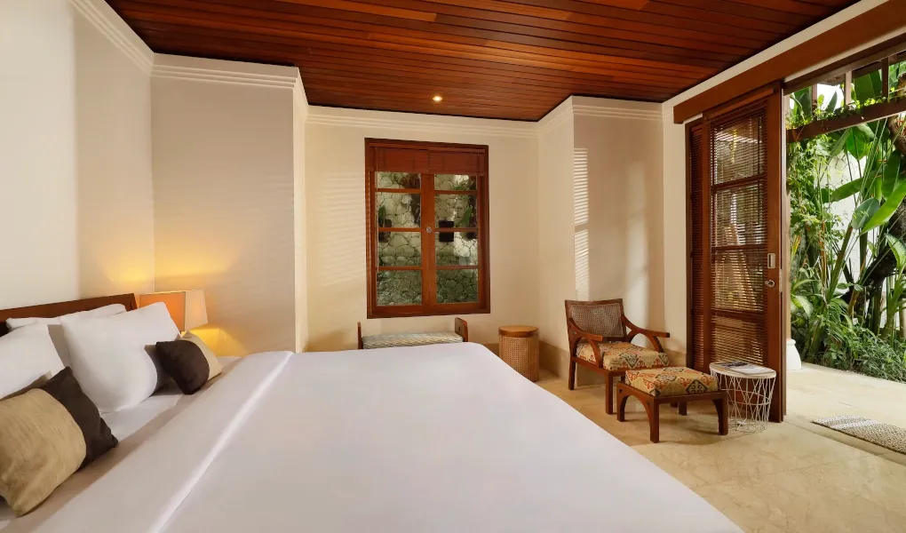 Bedroom with queen bed and tropical garden view at Villa Edward