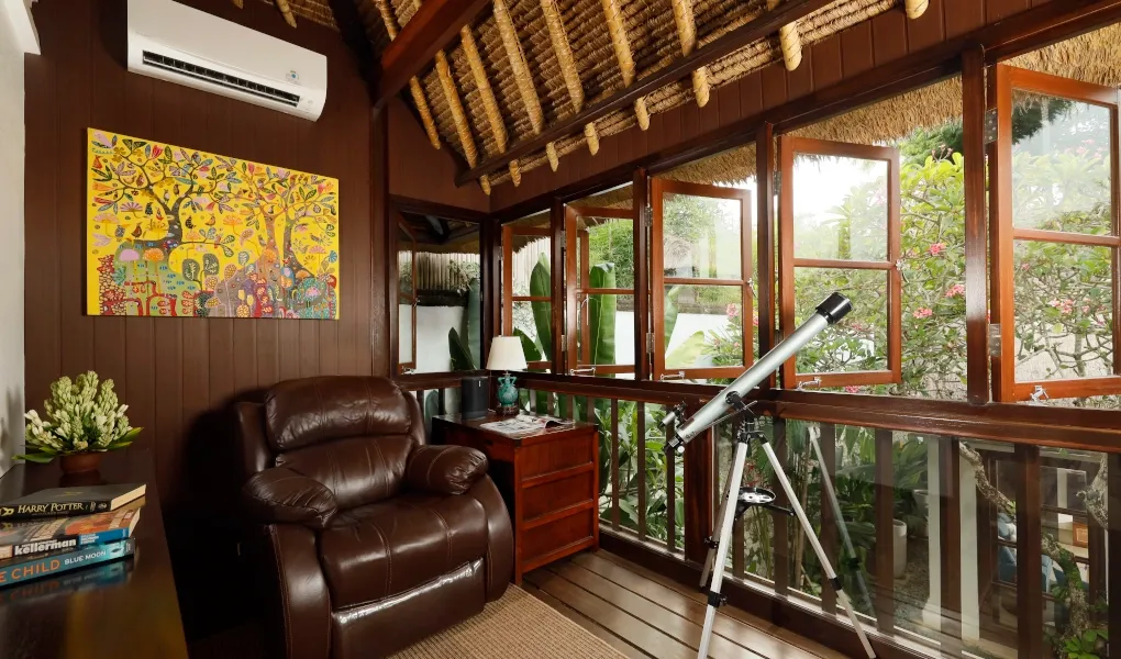 Cozy reading nook with telescope and vibrant art at Villa Edward