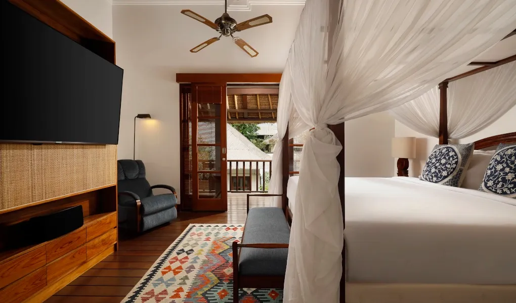 Elegant master bedroom with canopy bed and balcony at Villa Edward