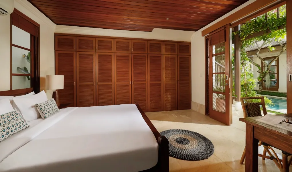 Luxurious bedroom with large wardrobe and pool access at Villa Edward