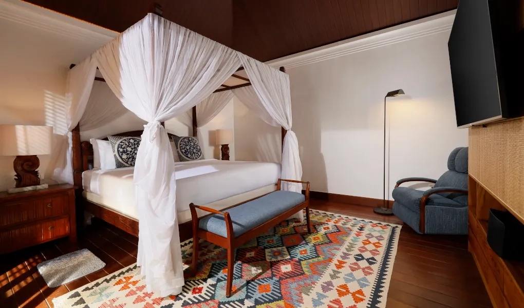 Luxurious master bedroom with canopy bed and television at Villa Edward