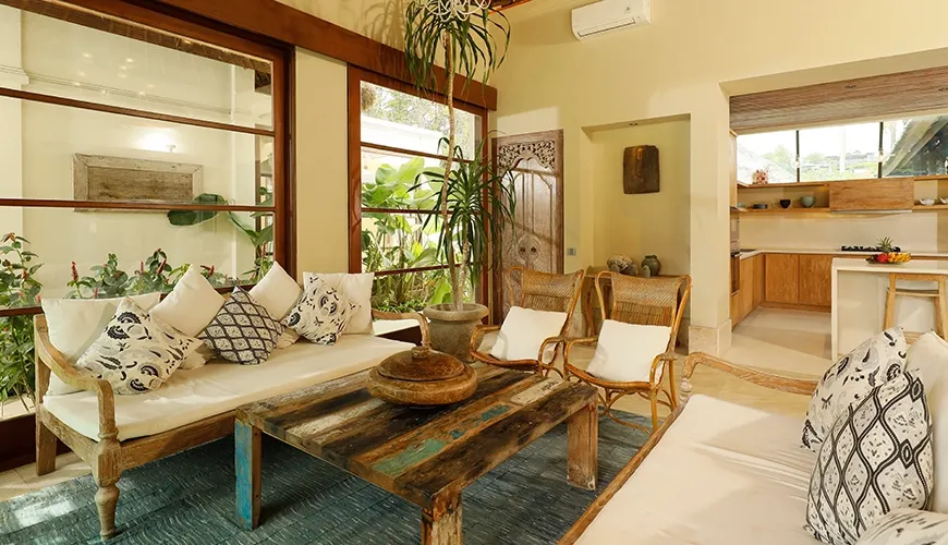 Charming villa living room with natural wood seating, weathered coffee table, and an adjacent modern kitchen area at Villa Grasshopper