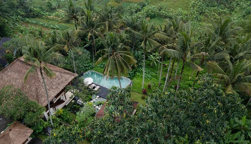 Aerial drone shot showcasing a beautiful villa with a pool nestled in a lush, green tropical landscape at Villa Inka