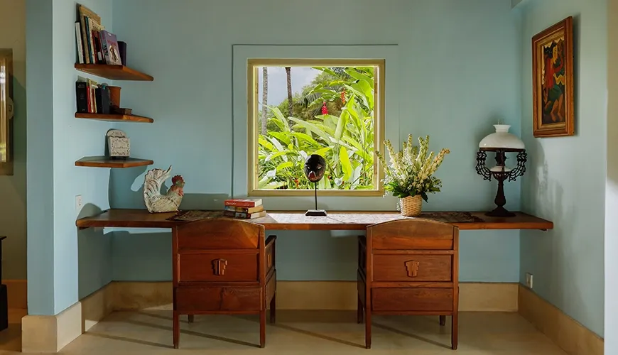 Cozy master bedroom working desk with traditional wooden chairs and a beautiful view of vibrant tropical plants at Villa Inka
