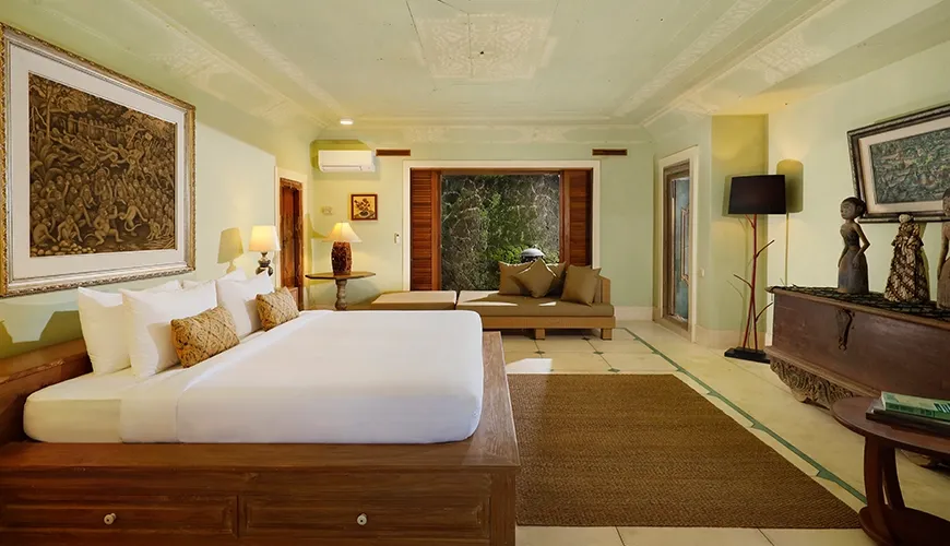 Spacious villa bedroom with a cozy daybed and large art pieces, creating a peaceful and artistic atmosphere at Villa Inka