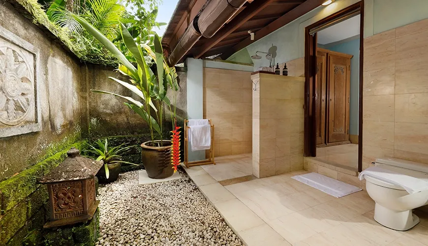 Stunning outdoor villa bathroom featuring a shower area, lush tropical plants, and a small pebble garden at Villa Inka