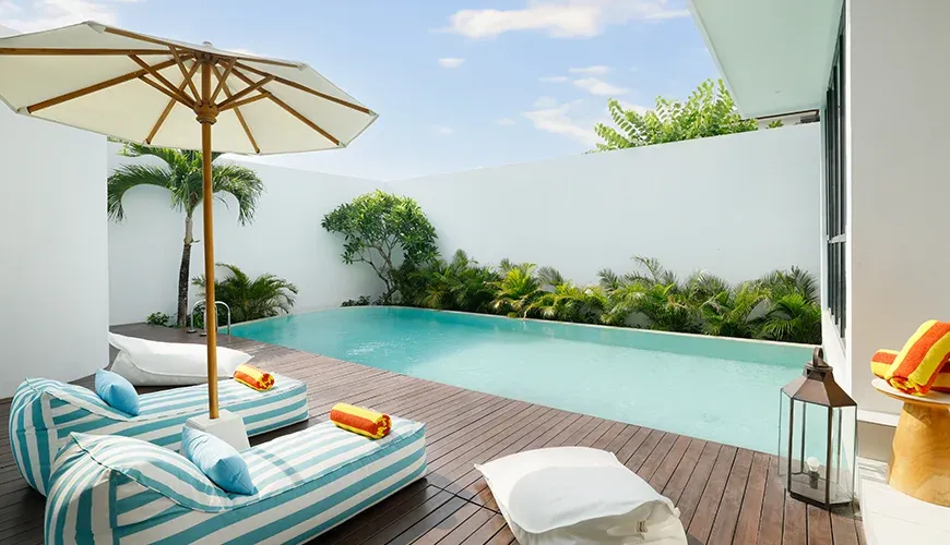Beautiful swimming pool with a wooden deck and bean bags at Villa Kalem Canggu