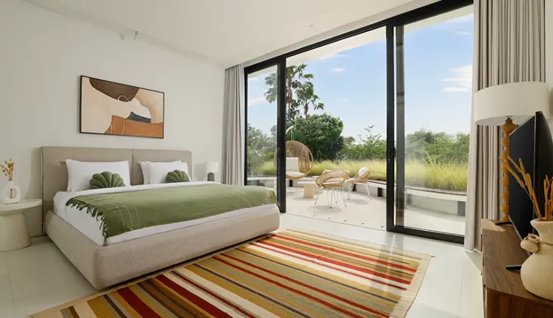 Elegant master bedroom with glass doors to a terrace at Villa Kalem Canggu