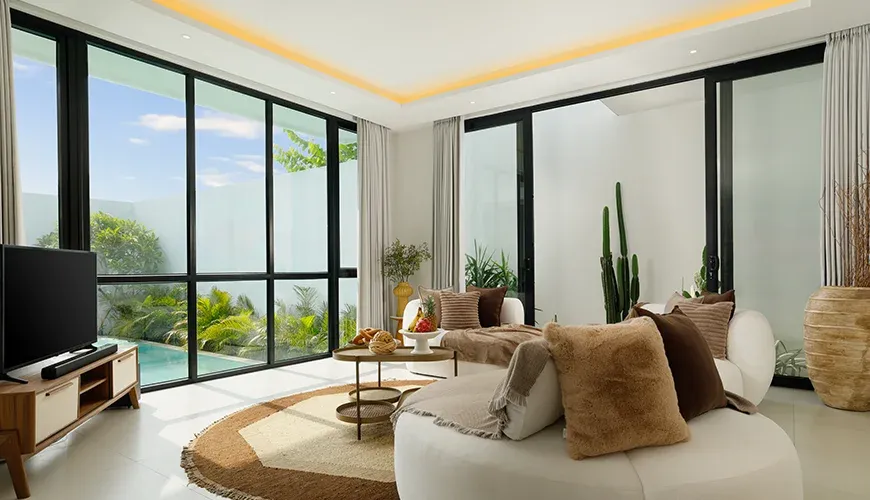 Modern living room with large windows and pool view at Villa Kalem Canggu