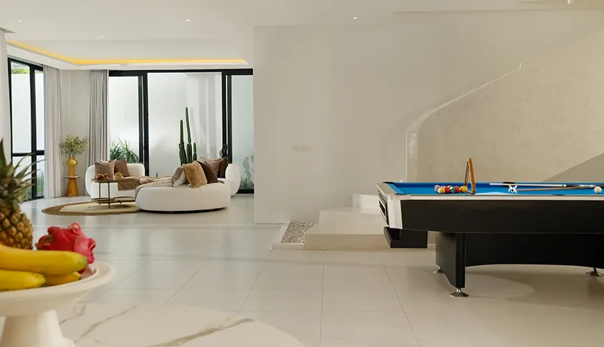 Spacious modern living area features billiard table, separate lounge, with pool views at Villa Kalem Canggu