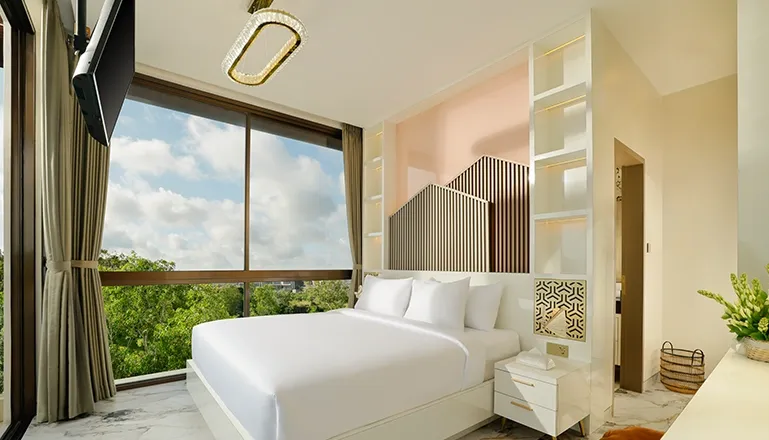 Contemporary bedroom white bed unique headboard large window green view at Villa Kalem Uluwatu