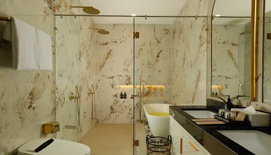 Elegant bathroom marble walls gold fixtures dual sinks modern design at Villa Kalem Uluwatu