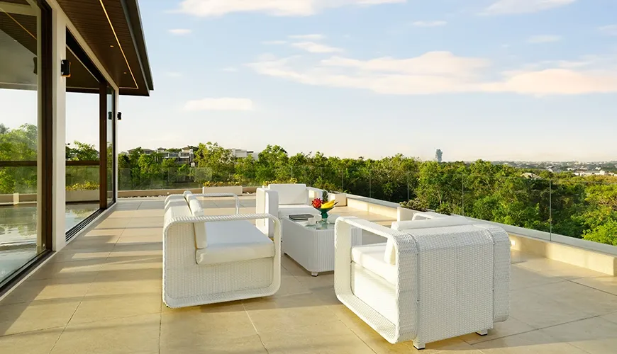 Spacious rooftop terrace white outdoor furniture clear sky green trees at Villa Kalem Uluwatu