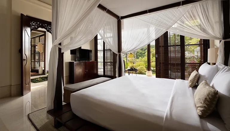 Bedroom with canopy bed offering views of private balcony at Villa Ken