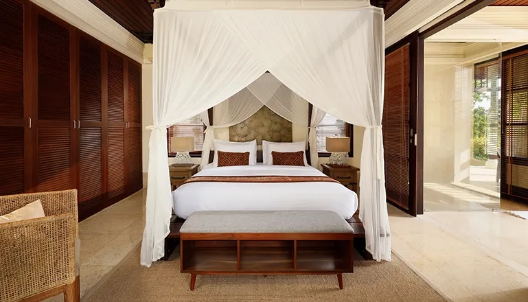 Bedroom with canopy bed wooden wardrobes and bright outdoor view at Villa Ken