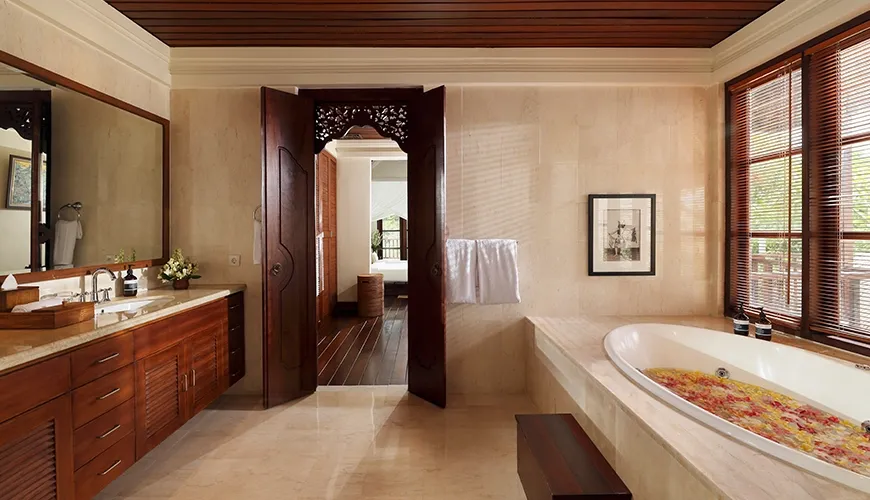 Luxurious bathroom with petal-filled tub and spacious double vanity at Villa Ken