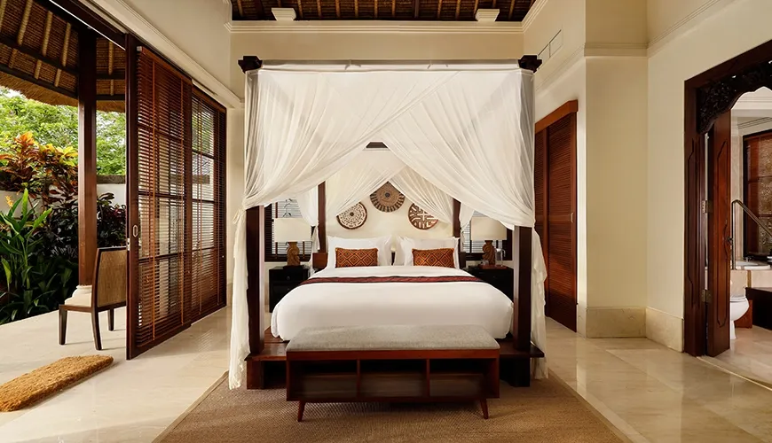 Luxurious private villa bedroom featuring a stunning canopy bed and direct access to the tropical outdoors at Villa Ken