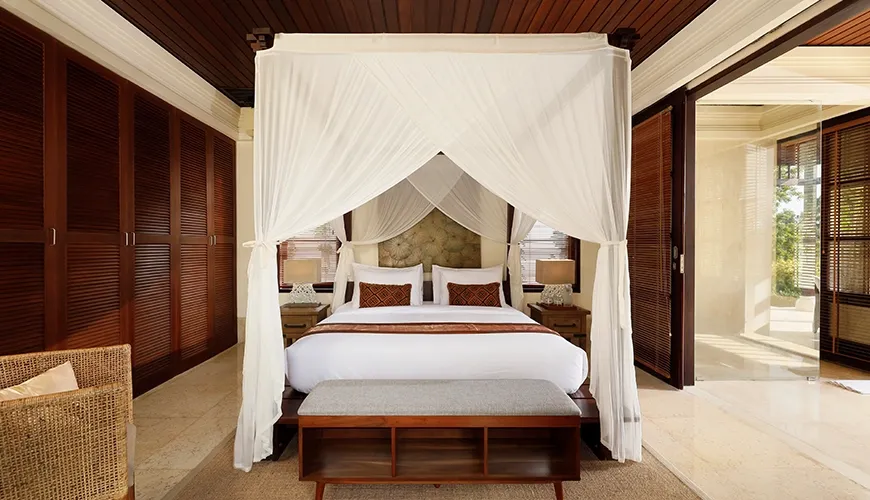 Luxurious and spacious private villa bedroom with a stunning canopy bed and rich wooden furnishings at Villa Ken