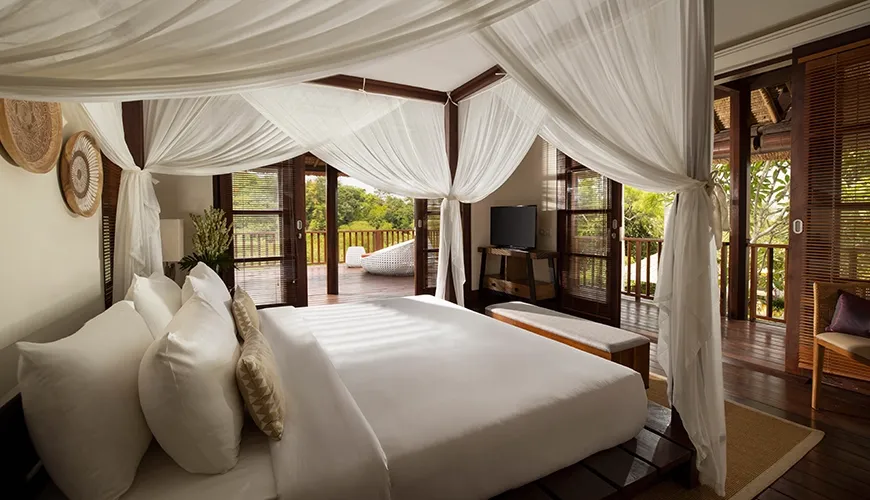 Spacious bedroom with canopy bed and private balcony with views at Villa Ken