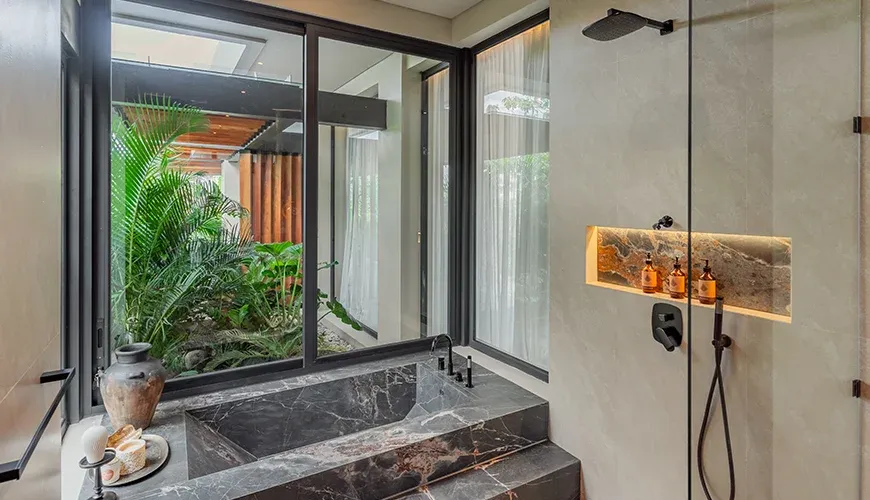 Stylish bathroom with a modern tub and outdoor greenery at Villa Morada