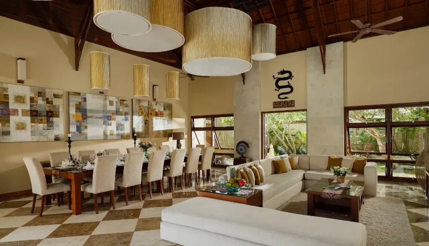 Spacious open-plan living and dining area with high ceilings and a long table at Naga Sutra Villa