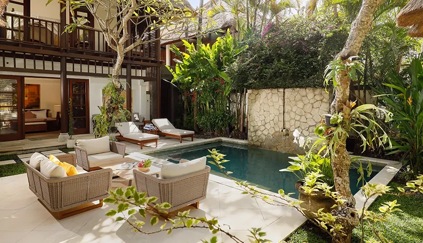 Serene villa swimming pool surrounded by lush tropical plants and comfortable seating for relaxation at Villa Nayra
